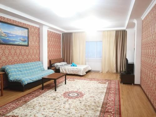 un soggiorno con divano e tavolo di Северное Сияние 41 этаж 01 a Astana