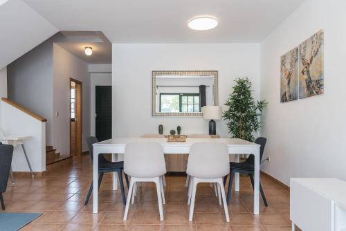 une salle à manger avec une table et des chaises blanches dans l'établissement Residencial Las Candelarias 36, à Agaete