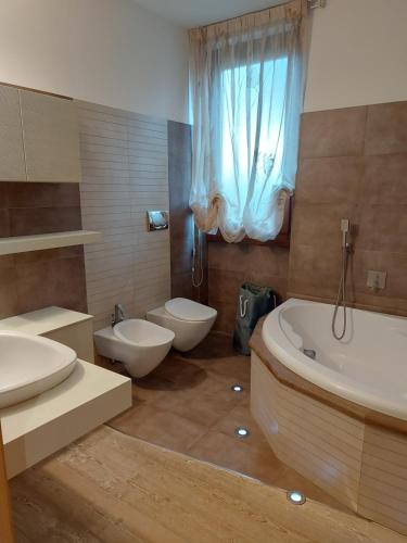 ein Badezimmer mit zwei Waschbecken, einer Badewanne und einem WC in der Unterkunft Il Melograno in Toscana in Castelfranco di Sopra