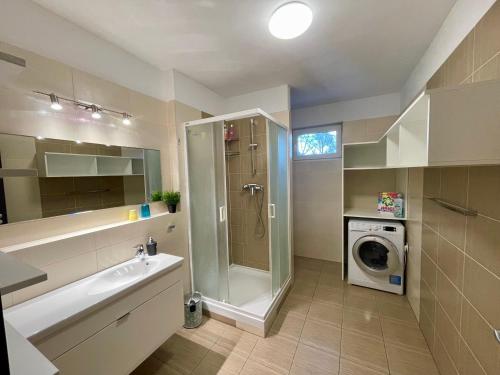 łazienka z umywalką i pralką w obiekcie Apartment Rosnička, Perfect Location with 24h Checkin, Balcony, AC & Free Parking w Bratysławie