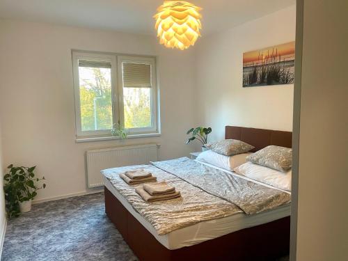 1 dormitorio con 1 cama con toallas en Apartment Rosnička, Perfect Location with 24h Checkin, Balcony, AC & Free Parking, en Bratislava