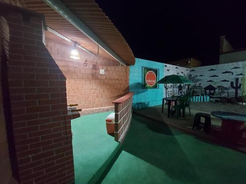 - une piscine avec une table et un parasol la nuit dans l'établissement Pousada Naturaly, à Serra Caiada