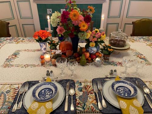 un tavolo con piatti e utensili e fiori di Le Macassar a Corbie