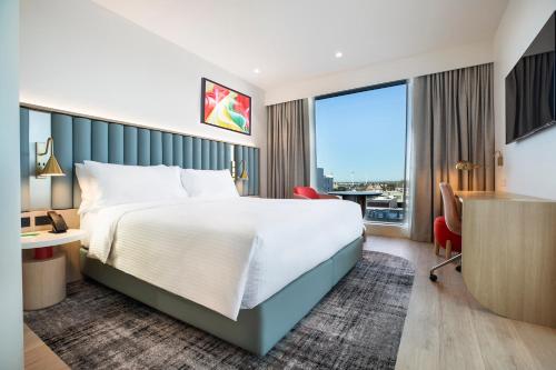 a hotel room with a bed and a large window at Holiday Inn & Suites Geelong by IHG in Geelong
