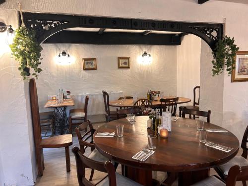 a dining room with wooden tables and chairs at The Cottage Inn in Llandeilo