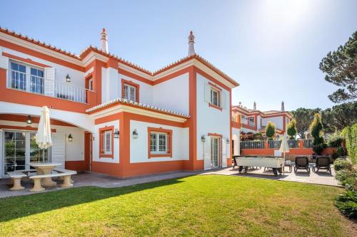 a large orange and white house with a yard at 4 Bed Private Villa Ribeiro II with heated pool, garden, wi-fi in Albufeira