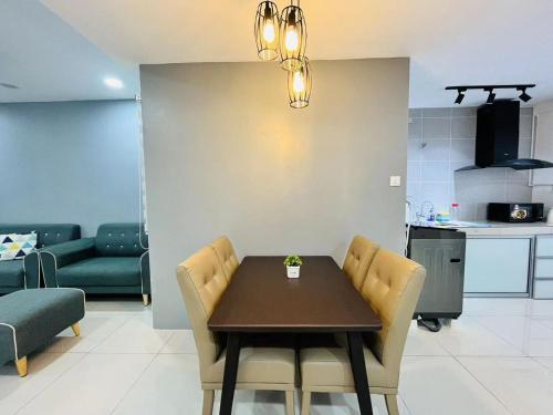ein Esszimmer mit einem Tisch und Stühlen sowie eine Küche in der Unterkunft P3 Cozy Stay / Waterpark / 7-8pax Ipoh in Ipoh