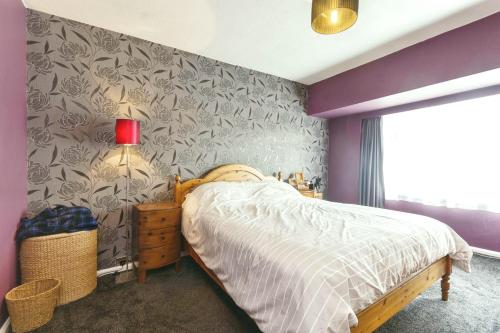 ein Schlafzimmer mit einem Bett und einer lila Wand in der Unterkunft Luxury Plan Gorret in Courmayeur in Courmayeur