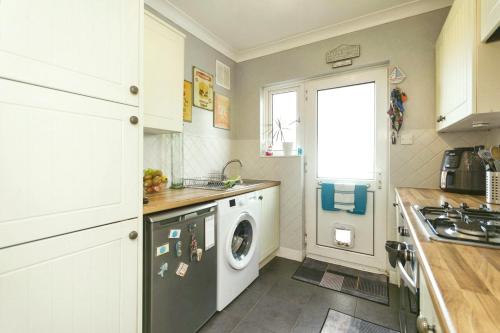 eine Küche mit einer Waschmaschine und einem Fenster in der Unterkunft Luxury Plan Gorret in Courmayeur in Courmayeur