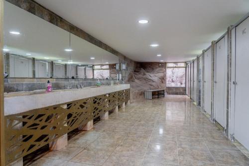 a large bathroom with two sinks and a stone wall at Rahayeb Desert Camp in Wadi Rum