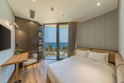 a bedroom with a bed and a view of the ocean at Taiyo Hotel & Apartment in Danang