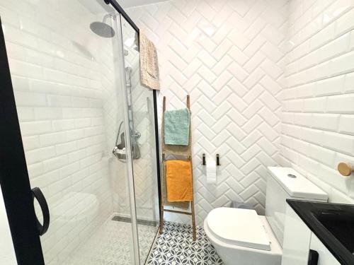 a white bathroom with a shower and a toilet at Loft B El Ramellet in Alginet