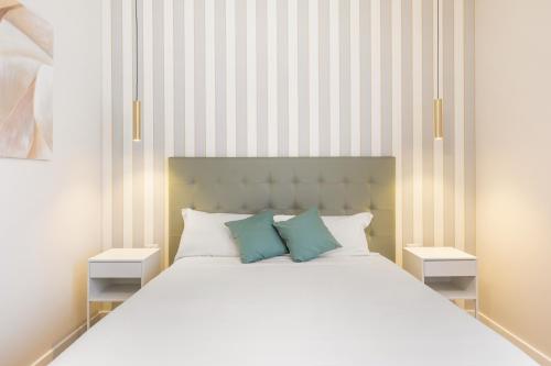 ein Schlafzimmer mit einem weißen Bett und zwei Nachttischen in der Unterkunft AlbaDea Apartment in Rom