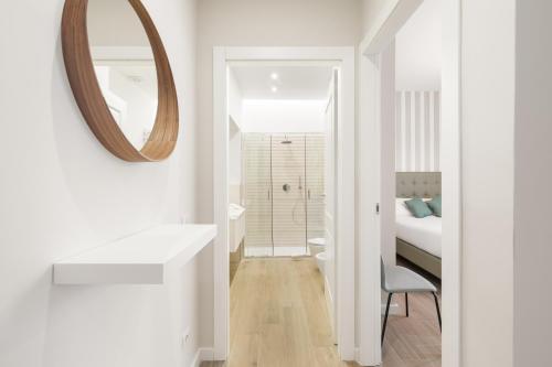 ein weißes Badezimmer mit einem Waschbecken und einem Spiegel in der Unterkunft AlbaDea Apartment in Rom