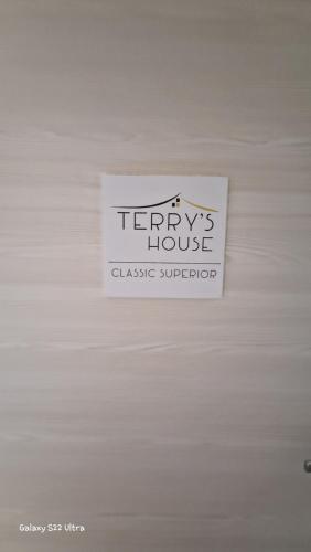 a sign on a white wall with a sign on it at Terry's House in Nuoro