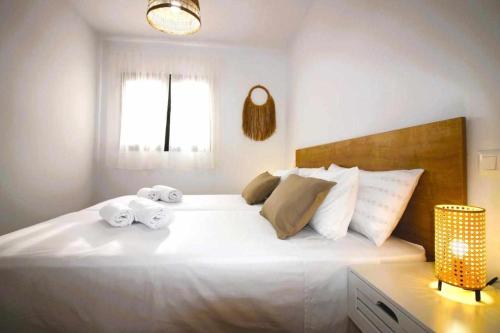 een slaapkamer met een groot wit bed en handdoeken bij Blue Sand Apartment in Costa Teguise in Costa Teguise