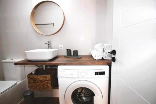 een badkamer met een wasmachine en een wastafel bij Blue Sand Apartment in Costa Teguise in Costa Teguise