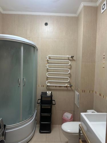 ein Bad mit einer Dusche, einem WC und einem Waschbecken in der Unterkunft 4-х комнатная квартира in Astana