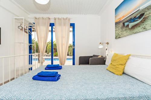 a bedroom with a bed and two blue towels on the floor at Villa Valentina Private Pool Playa Blanca By PVL in Playa Blanca