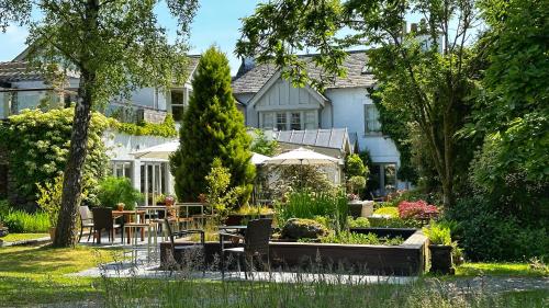 una casa con tavolo e sedie in giardino di Gilpin Hotel & Lake House a Bowness-on-Windermere