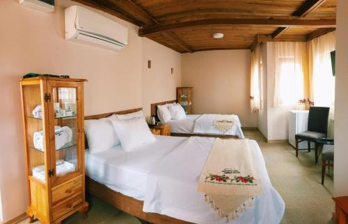um quarto com duas camas e uma cadeira. em Osmanlı Paşa Otel- Konaklama em Samsun