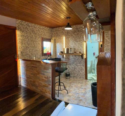a kitchen with a bar in the middle of a room at Chalé Recanto Dos Encantos in Lavras Novas