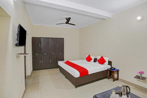 a bedroom with a bed and a flat screen tv at OYO Hotel Dreamland Residency in New Delhi