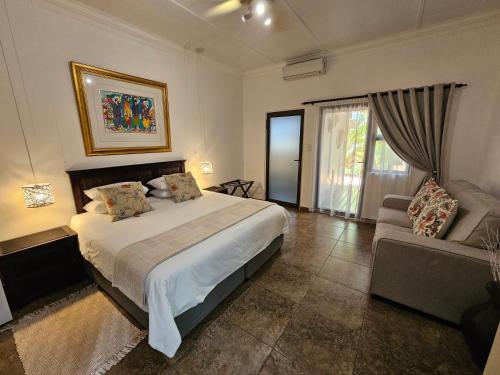 a bedroom with a large bed and a couch at Leopard Corner Lodge in St Lucia