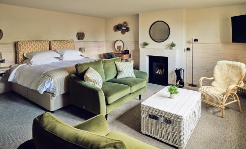 a bedroom with a bed and a couch and a fireplace at The Fish Hotel in Broadway