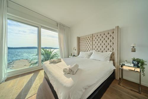 una camera da letto con un grande letto con una grande finestra di Livingstone Beach House a Trogir