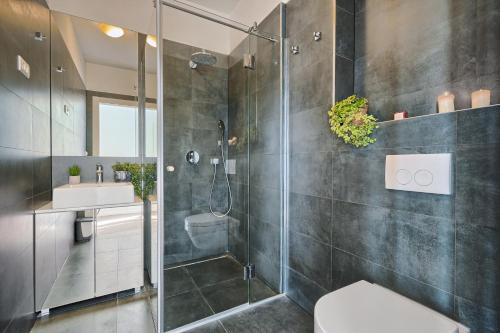 a bathroom with a shower and a toilet and a sink at Livingstone Beach House in Trogir