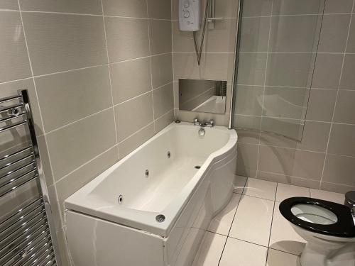 eine weiße Badewanne im Bad mit WC in der Unterkunft Glazert Country House Hotel in Lennoxtown