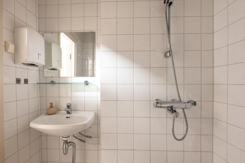 a bathroom with a sink and a shower at 2ndhomes Bright & Spacious, 5 Bedroom Apartment in the Center in Helsinki
