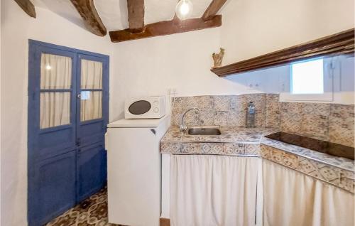 eine Küche mit einem Waschbecken und einer blauen Tür in der Unterkunft Gorgeous Home In El Gastor With Kitchenette in El Gastor