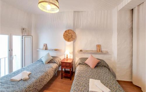 ein Wohnzimmer mit 2 Betten und einem Tisch in der Unterkunft Gorgeous Home In El Gastor With Kitchenette in El Gastor