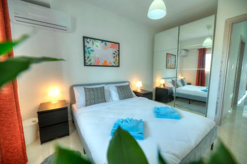 1 dormitorio con 1 cama con 2 toallas azules en Bright & modern 2bedrooms with sea views GOGZR1-2, en Il-Gżira