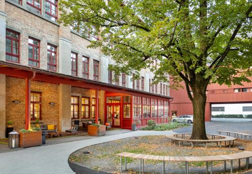 a building with a tree in the middle of a courtyard at JUFA Hotel Bregenz in Bregenz