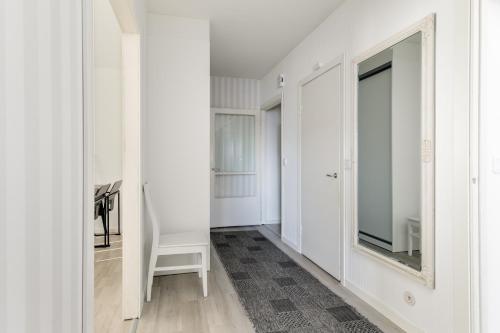 a hallway with white walls and a mirror at Santa's Holiday Homes in Rovaniemi