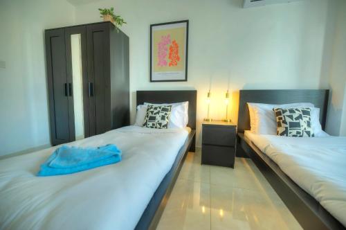 two beds sitting next to each other in a room at Bright & modern 2bedrooms with sea views GOGZR-2 in Il-Gżira