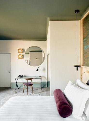 a bedroom with a white bed and a table at Palazzo Velabro, a Member of Design Hotels in Rome