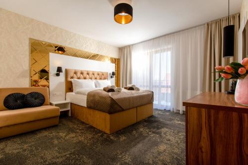 Habitación de hotel con cama grande y sofá en Pokoje z wyżywieniem i krytym basenem w Amber Park Spa, en Niechorze