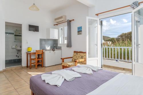 a bedroom with a bed and a kitchen with a balcony at Livadia Studio A Paros in Parikia