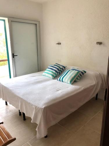 Bett in einem Zimmer mit zwei Kissen darauf in der Unterkunft VILLA MARE in Rena Majore
