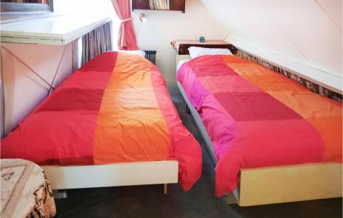 two beds with colorful sheets in a room at 2 Bedroom Cozy Home In Noordwijkerhout in Noordwijkerhout