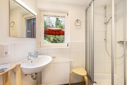 a bathroom with a sink and a window with an umbrella at Ferienwohnungen Metzgerpost in Altensteig