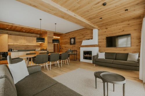 a living room and kitchen with a couch and a table at Boutique Chalet Almrausch in Lech am Arlberg