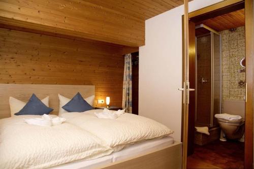 ein Schlafzimmer mit einem großen weißen Bett mit blauen Kissen in der Unterkunft Haus Trantrauas in Gaschurn
