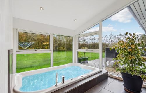 a large bath tub in a room with windows at 3 Bedroom Lovely Home In Hemmet in Hemmet