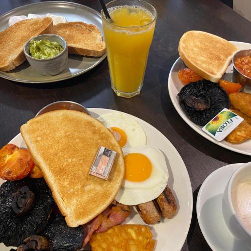 a table with two plates of breakfast food and a glass of orange juice at China Fleet Country Club in Saltash