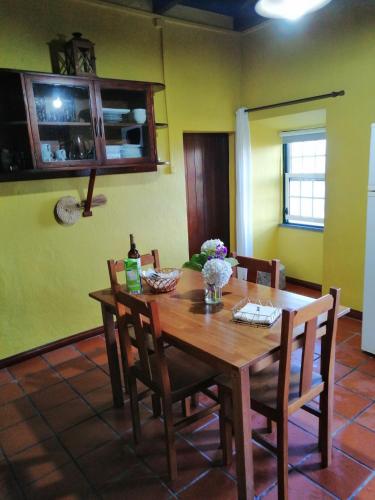 - une table à manger et des chaises dans la cuisine dans l'établissement Cantinho da Terra Alta, à Santo Amaro